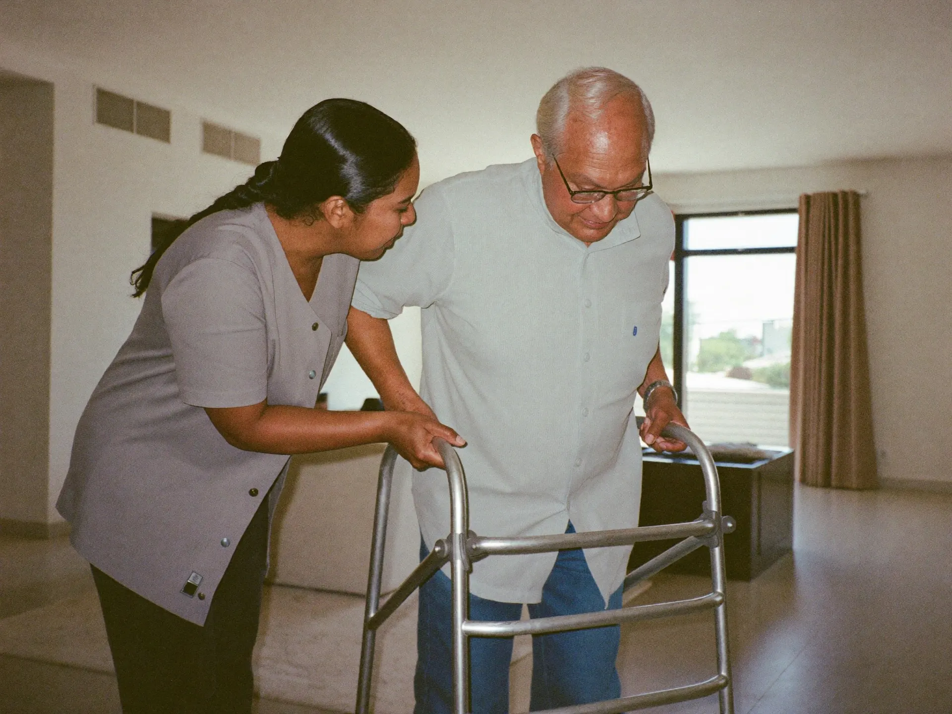 An Indian caregiver helping an elderly person at home