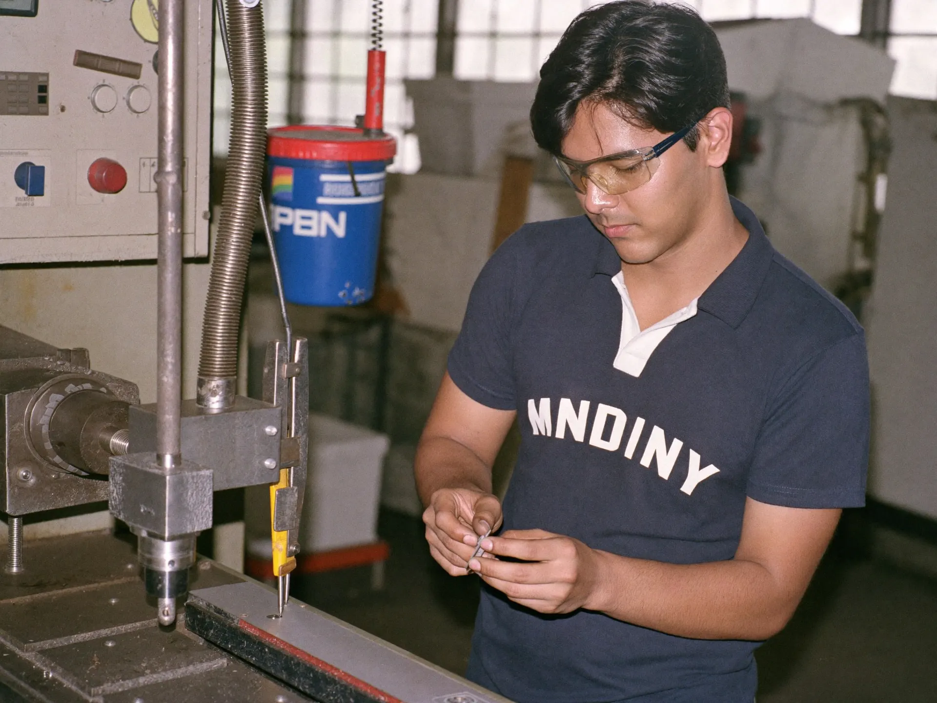 An Indian CNC operator setting up a machine on a factory floor